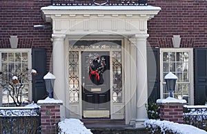 house with portico entrance and Christmas decoration on front door