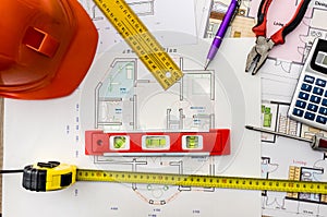 House project drawings with helmet, mason tools