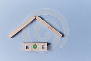 House protection. Commercial property insurance. Wooden blocks with lock, shield signs. Copy space. Isolated on blue