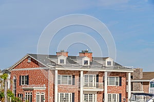 House with red brick wall gable roof dormers and balcony in Huntington Beach CA