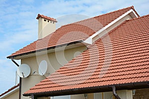 Roofing Construction. House with red clay tiled roof and gable and valley type of roof construction.