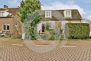 a house with a red door and a brick driveway