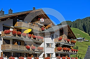 House with red geraniums on the balconies photo