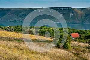 House with red roof on the slopes of the Dniester. The flooded village of Bakota. Ukrainian landscapes