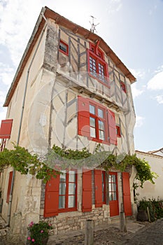 House with red shutter in old village in france