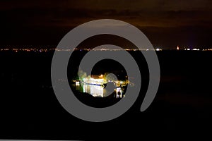 The house is reflected in the water. Night landscape with a stormy sky