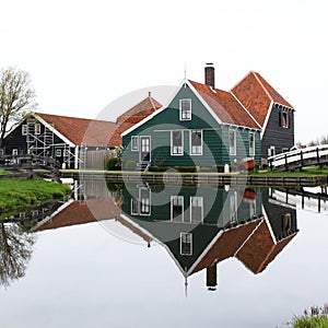 A HOUSE REFLECTING AT THE CALM WATERS OF ZAANSE SCHANS
