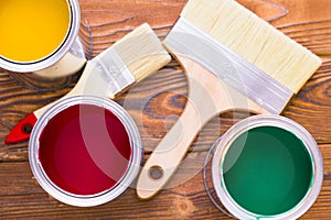 House renovation concept, colorfull paint cans and paintbrushes on dark wooden background