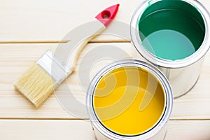 House renovation concept, colorfull paint cans and paintbrushes on wooden background