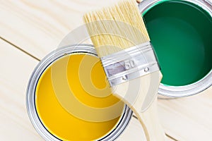 House renovation concept, colorfull paint cans and paintbrushes on wooden background