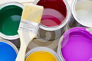 House renovation concept, colorfull paint cans and paintbrushes on wooden background