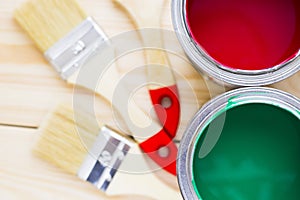 House renovation concept, colorfull paint cans and paintbrushes on wooden background