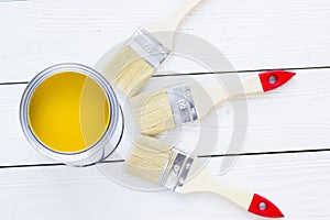 House renovation concept, colorfull paint cans and paintbrushes on wooden background