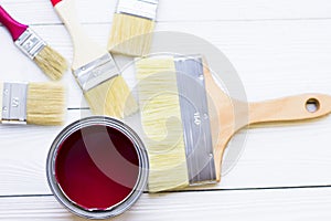 House renovation concept, colorfull paint cans and paintbrushes on wooden background