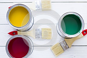 House renovation concept, colorfull paint cans and paintbrushes on wooden background