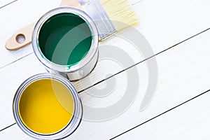 House renovation concept, colorfull paint cans and paintbrushes on wooden background