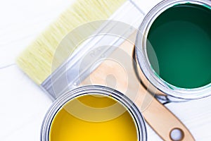 House renovation concept, colorfull paint cans and paintbrushes on wooden background