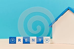 House for rent. Online rental property. Real estate. Miniature house, place for text isolated on blue. Wooden blocks