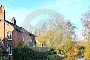 house resting by river in English countryside