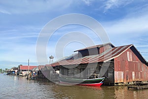 house by the river under the blue sky with the red speedboat