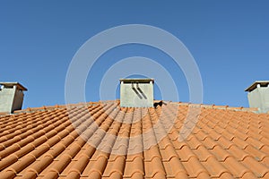 House roof with chimneys and blue sky