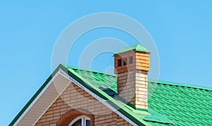 house with a roof from a green shingles with a pipe