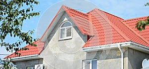 House roof with guttering pipeline and metal complicated roofing construction