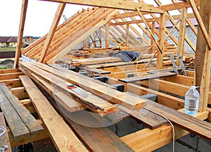 House roofing construction panorama. Installing wooden rafters, eaves, waterproofing logs with bitumen