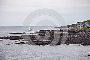 House and Sailboat near Oarweed Cove along the rocky coast of Maine in Ogunquit