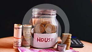 House saving money,financial planning concept,coins and rupees on table,home saving coins in jar,real estate investment,indian