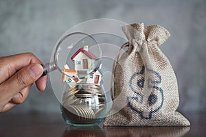 House searching concept with a magnifying glass, house and money. magnifying glass and coins. concept of mortgage, construction,