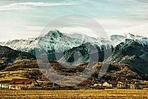 House settlement at the base of the mountains under the cloudy sky