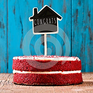 House-shaped chalkboard with the text congrats in a cake, with a