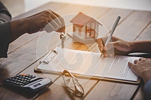 House signers signing signature loan document to home ownership with real estate agents ownership. Mortgage and real estate photo