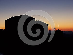 House silhouetted at sunset