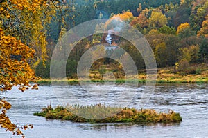 house with smoke in deep forest, autumn nature