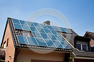 House with solar panel system on roof in Germany. Photovoltaic solar system on a roof surface. Installed sun collectors on a top