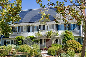 House with solar panels on the roof in a residential neighborhood of Oakland, in San Francisco bay on a sunny day, California