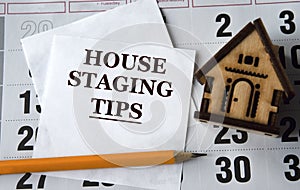HOUSE STAGING TIPS - words on white paper on the background of a house, pencil and calendar