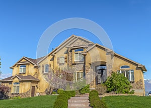 House with stairs on the landscaped yard leading to the wrought iron front door