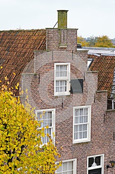 House with a stepped gable and tree with autumn leaves