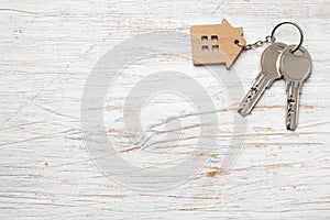 House symbol with silver keys on wood. Real estate concept