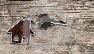 House symbol with silver keys on wood. Real estate concept