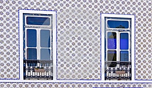 House with two windows decorated with traditional ceramic Portuguese tiles