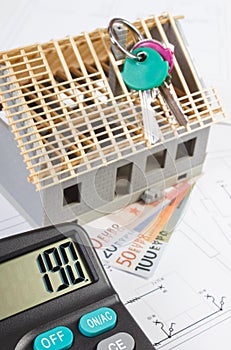 House under construction, keys, calculator and currencies euro on electrical drawings, concept of building home