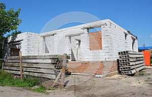House under construction with no roof, brick foundation and aerated concrete blocks