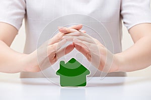 House under woman`s hands. Insurance and house protection concept