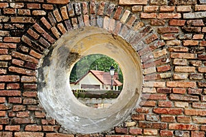 A house view through a cannon embrasure in Dutch fort Pangkor island photo