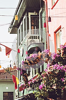 House vtinage flowers on a balcony flower arrangement green facade and pink wall with flags and windows rose roses