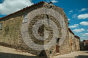 House with wall made of stone in an alley on slope